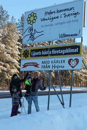 Infartsskylt vid E16 tillsammans med upphovsmakarna till Musikhjälpens insamling MEd kärlek från Hofors.